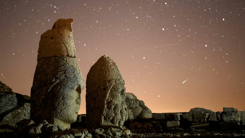 FILE - Ancient statues are seen during the Perseid meteor shower atop Mount Nemrut in...