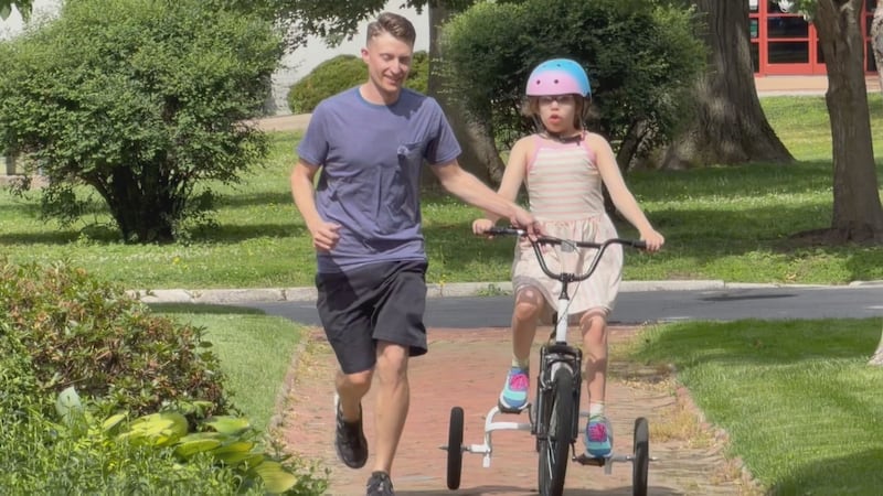 Poppy rides her "go cart" with dad